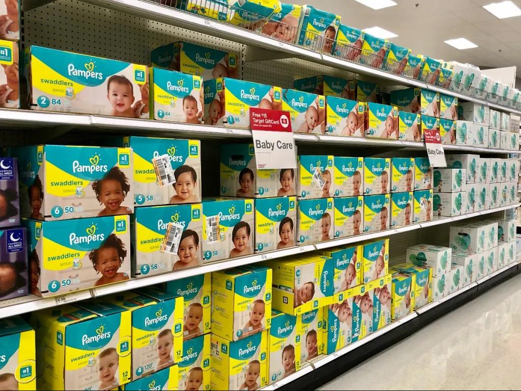 Parents selecting baby diapers in a store aisle